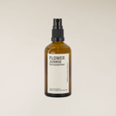 Amber brown glass "Flower Junkie" 100ml roomspray bottle with a black pump top and white label.
