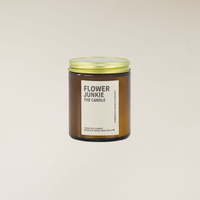 Flower Junkie 150gm soy candle in an amber glass jar with a gold lid and cream label.