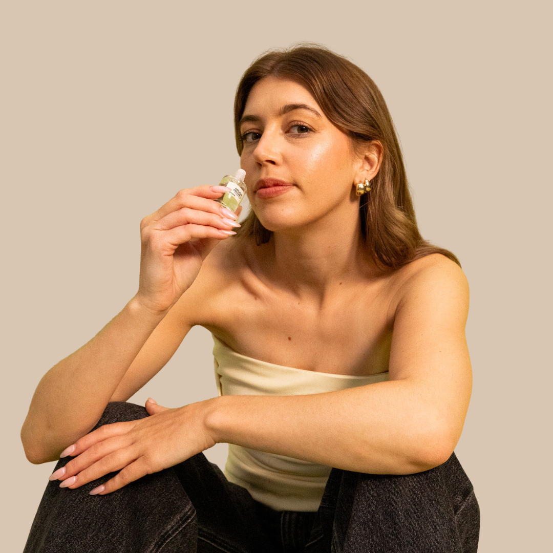 Woman holding a 12ml Mister Vanilla perfume oil roll-on bottle, featuring a light green label.