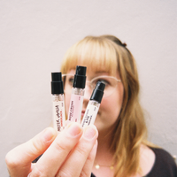 Hand holding three 2.5ml perfume sample spray vials: Mister Vanilla, Rose Crush, and Brown Sugar & Fig.