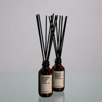 2 reed diffusers by Amberjack on a glass surface