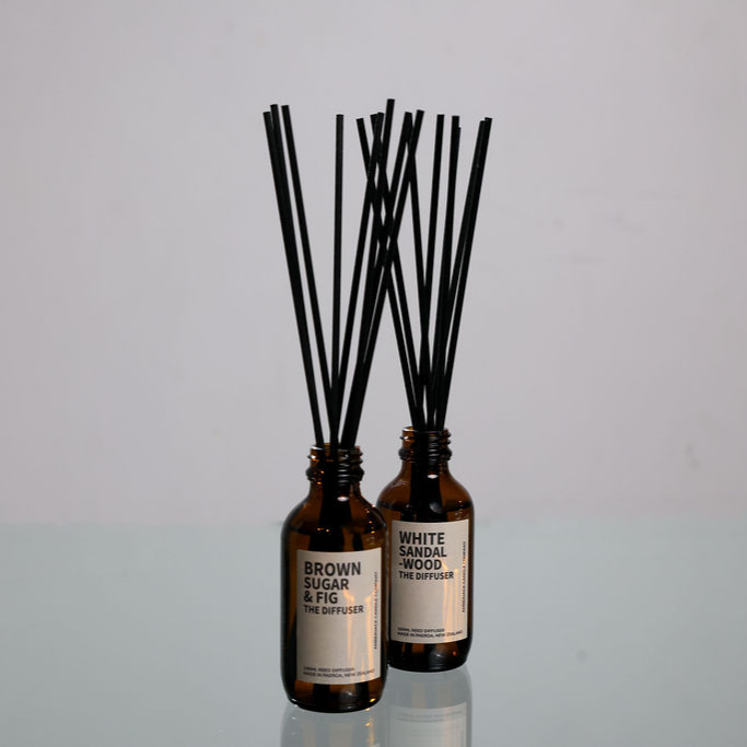 2 reed diffusers by Amberjack on a glass surface