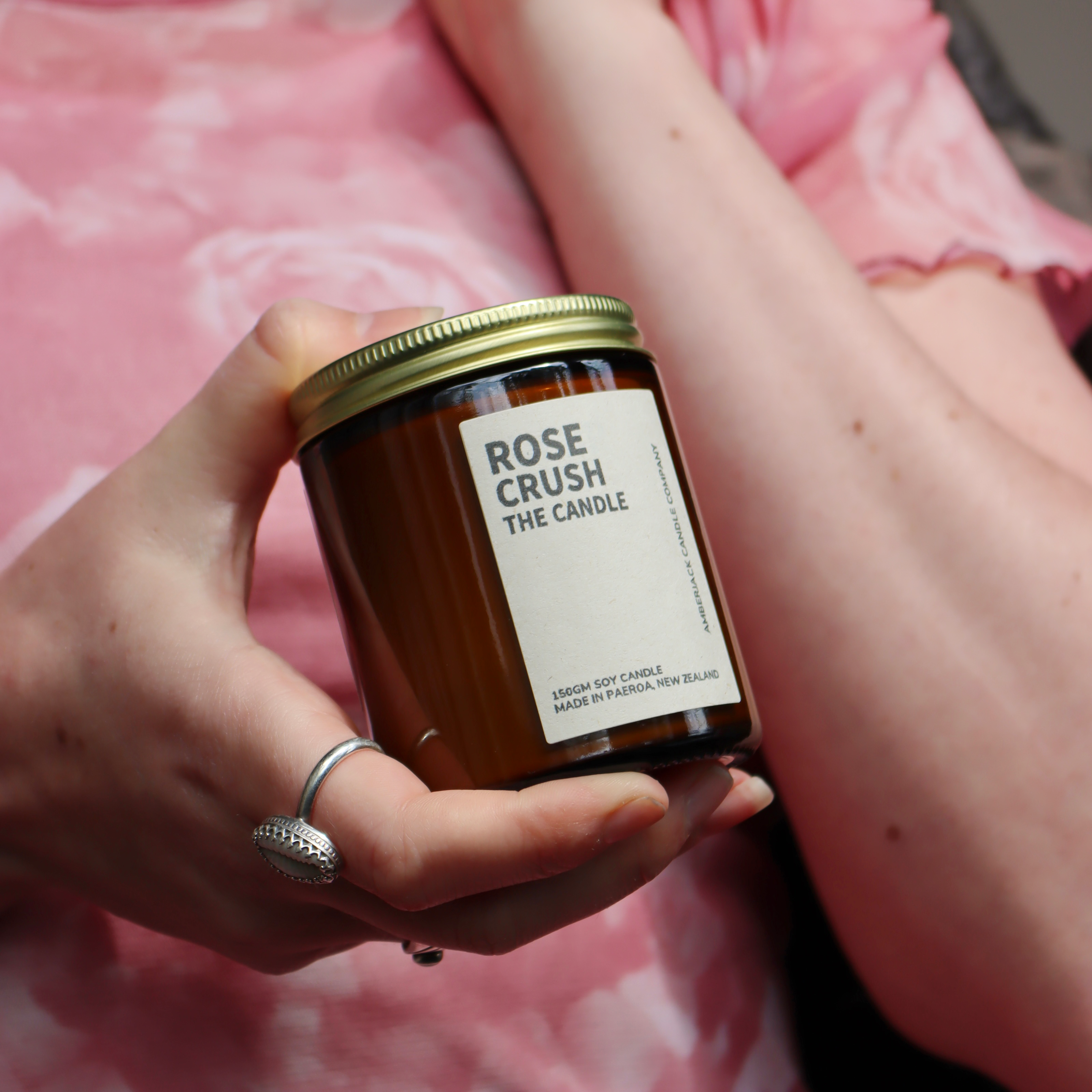 Soy candle regular size in rose crush fragrance in an amber glass jar