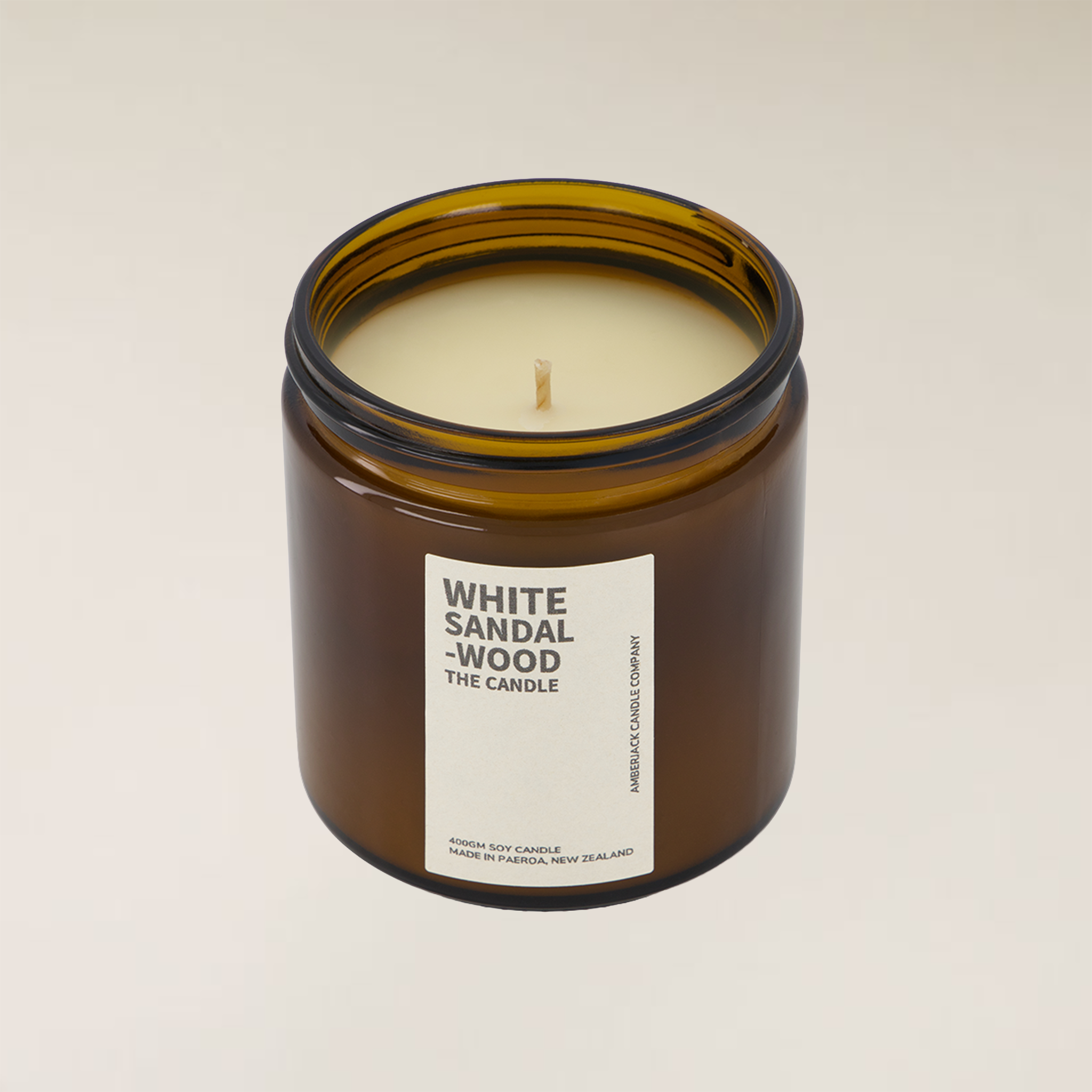 White Sandalwood soy candle in a brown amber glass jar with a cream label.