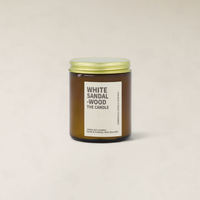 Amberjack White Sandalwood soy candle in a brown glass jar with a gold lid and minimalist label.